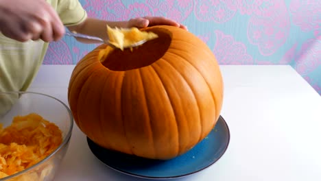 Halloween.-Children's-hands-hollow-out-a-pumpkin-to-make-a-jack-o-lantern