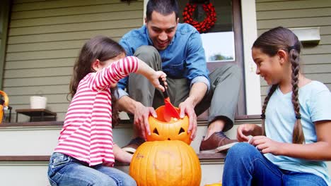 Padre-e-hijas-talla-de-calabaza-de-Halloween-en-casa-pasos