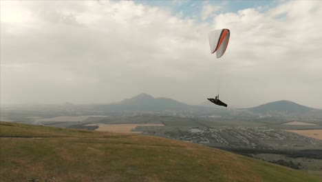 Athlet-Gleitschirm-fliegt-auf-seinem-Gleitschirm-neben-die-Schwalben.-Follow-up-Aufnahmen-aus-der-Drohne