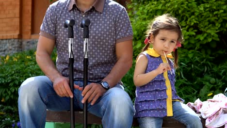 A-man-and-a-little-girl-are-sitting-on-a-bench.