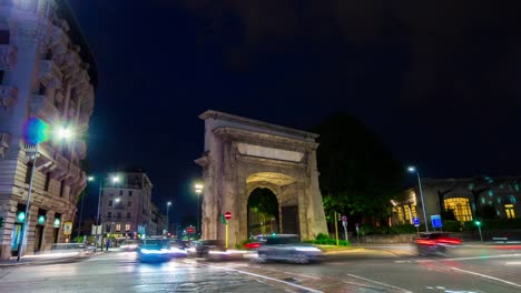 Iluminada-de-noche-Italia-Milán-ciudad-tráfico-calle-panorama-Plaza-arco-4k-timelapse