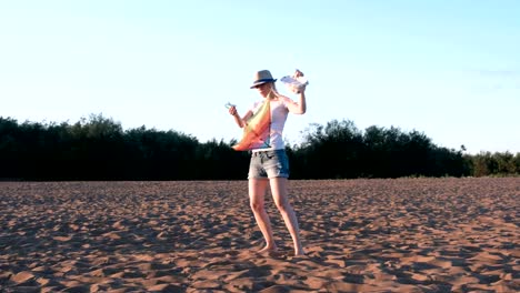 Preciosa-rubia-en-un-sombrero-lanza-una-cometa-en-la-playa.