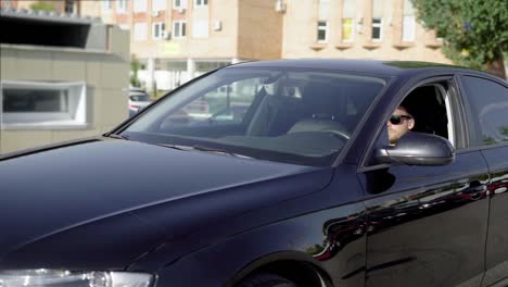 Shot-of-a-businessman-driving-a-clean,-shiny-black-car