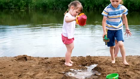 Little-children-play-in-the-river-in-the-summer.-Mom-looks-after-the-kids.