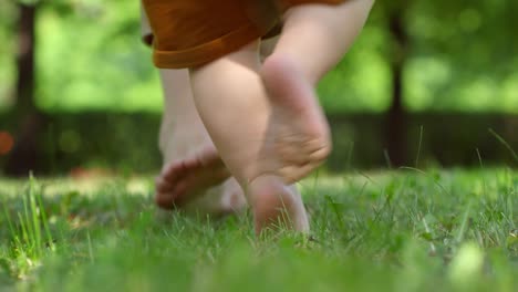 Legs-of-Mother-Teaching-Baby-to-Walk-Outdoors