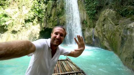 Junger-Mann-umarmt-schönen-Wasserfall-in-den-Philippinen