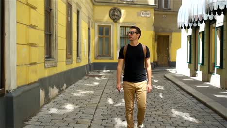 Man-tourist-with-a-city-map-and-backpack-in-Europe-street.-Caucasian-boy-looking-with-map-of-European-city.