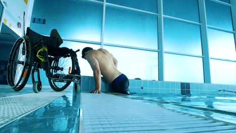 Disabled-man-gets-out-of-the-swimming-pool.-Side-view