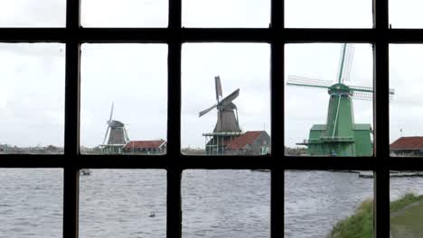 Windmühlen,-wie-durch-ein-Fenster-an-der-Zaanse-Schans-in-der-Nähe-von-Amsterdam-zu-sehen