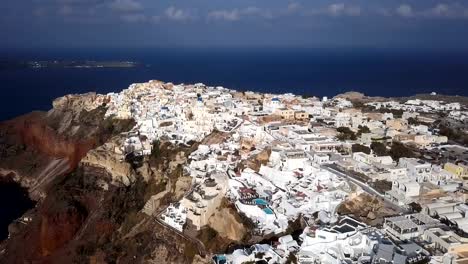 Flight-over-of-Oia-town-at-sunset,-Santorini-island,-Greece