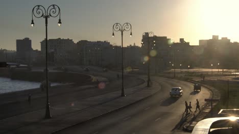 Vida-cotidiana-del-cubano,-luz-del-atardecer,-coches-de-época-de-1950-americano-clásico-en-barrio-viejo-de-la-Habana,-Cuba