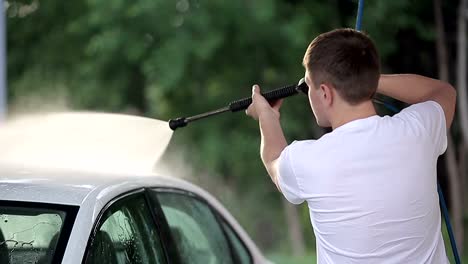 man-in-a-t-shirt-white-car-washes.-Slow-motion