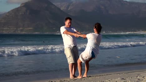 Slow-motion-of-romantic-couple-spinning-around-on-the-beach,-Cape-Town,South-Africa