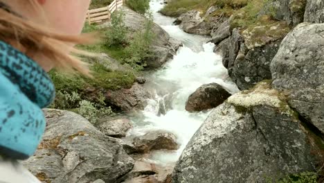 Mädchen-schauen-auf-den-Fluss-in-den-Bergen