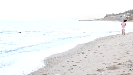 muchacha-en-la-mañana-corre-a-lo-largo-de-la-playa-cerca-del-mar