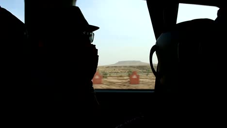 Young-woman-looking-trough-the-window-and-playing-with-hands-sitting-on-backseats-in-bus-during-road-trip