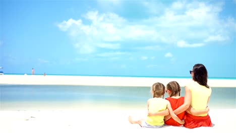 Adorable-little-girls-and-young-mother-on-white-beach