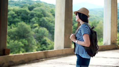 Young-female-traveler-with-backpack-looking-into-the-distance-in-ancient-city