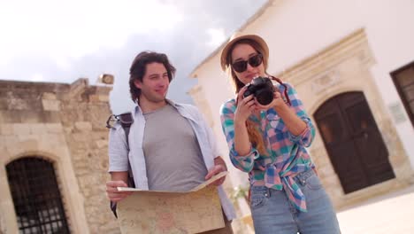 Turistas-con-mapa-y-cámara-tomando-fotos-en-el-casco-antiguo