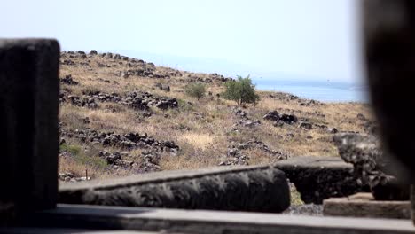 Peering-Through-Ruins-of-Ancient-Temple-at-Barren-Field-in-Distance