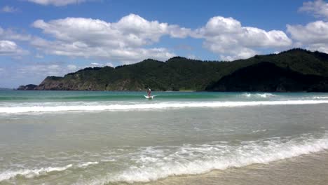 Paddleboarder-on-a-SUP-surfing-a-wave-at-Matauri-Bay,-Northland,-New-Zealand,-NZ