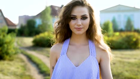 nice-and-slightly-sexy-woman-with-a-bright-make-up-in-the-style-of-rock-gel-touches-her-hair-and-confidently-goes-along-the-street-on-a-summer-day