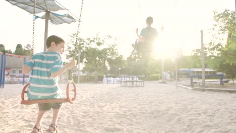 Niños-que-hace-pivotar-juntos-en-un-parque-infantil-público