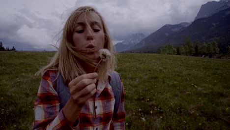 Young-woman-is-blowing-Dandelion-seeds-into-the-air