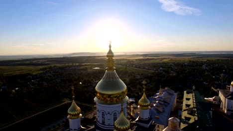 Symbol-of-christian-religion-on-the-top-of-the-church-at-sunrise-in-the-morning.-Sun-rays-behind-church's-domes-and-steeple