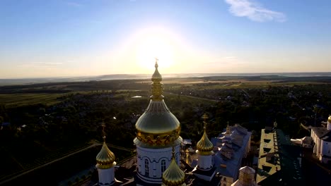 Símbolo-de-la-religión-cristiana-en-la-parte-superior-de-la-iglesia-al-amanecer-en-la-mañana.-Rayos-de-sol-detrás-de-cúpulas-y-el-campanario-de-la-iglesia