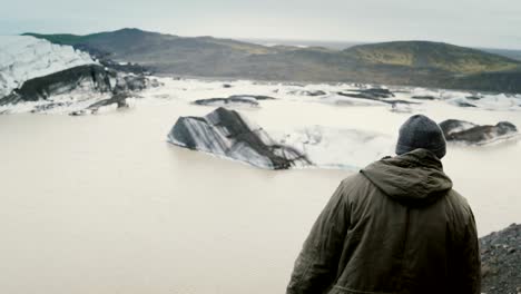 Schönen-jungen-Mann-Wandern,-Aufnahme-des-Vatnajökull-Eis-Lagune-mit-Gletscher-in-Island-auf-smartphone