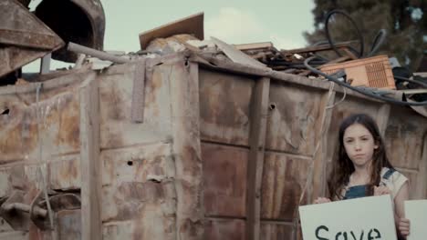 Chilfren-holding-signs-for-planet-Earth-standing-in-a-huge-junkyard