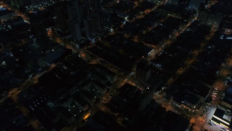 Top-View-of-Intersection,-Rooftops-and-illuminated-streets