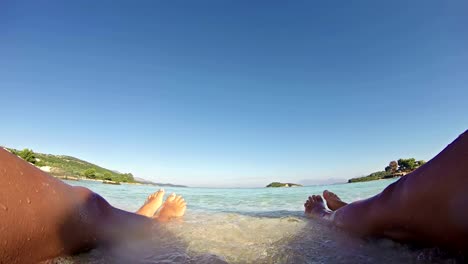 Schöne-gebräunte-Frauen-Beine-am-Strand-ein-Sonnenbad-nehmen.---SOMMER-KONZEPT