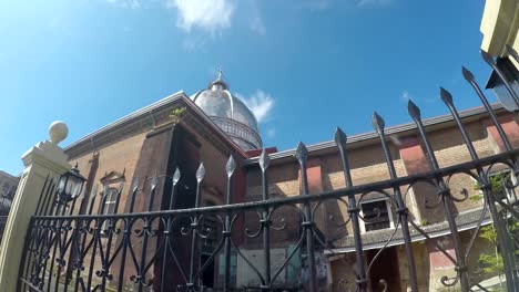 Colonial-16th-century-Spanish-built-of-Saint-Paul-the-First-Hermit-Cathedral-also-known-as-San-Pablo-Cathedral,-showing-her-surrounding-iron-fence-at-the-east-side-nave-brick-walls.-tracking-shot