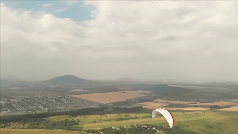 Athlet-Gleitschirm-fliegt-auf-seinem-Gleitschirm-neben-die-Schwalben.-Follow-up-Aufnahmen-aus-der-Drohne