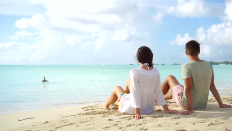 Young-couple-on-white-beach-during-summer-vacation