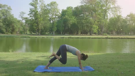 Junge-asiatische-Frau-Yoga-im-Freien-bleiben-Sie-ruhig-und-meditiert-beim-Üben-von-Yoga,-die-innere-Ruhe-zu-erkunden.-Yoga-und-Meditation-haben-gute-Vorteile-für-die-Gesundheit.-Yoga-Sport-und-gesunde-Lifestyle-Konzept.