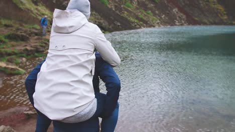 Young-man-and-woman-having-fun-and-playing-outdoors-near-the-lake