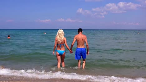 Young-couple,-man-and--beautiful-girl-walk-into-the-sea