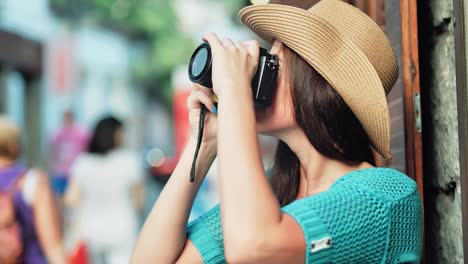 Happy-face-of-female-tourist-in-hat-taking-photo-using-professional-camera