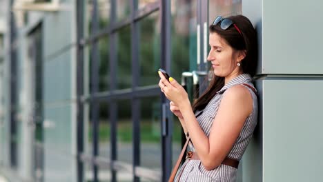 Chica-Europea-en-metrópolis-de-noche-con-smartphone-para-la-comunicación-o-charla