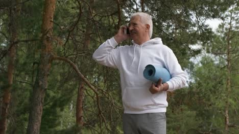Senior-hombre-hablando-por-teléfono-en-el-bosque