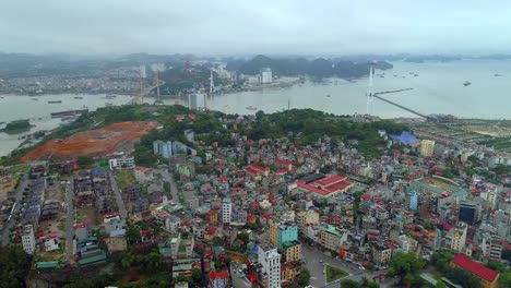 4k-Aerial-view-over-city-and-park-with-Bai-Tho-karst-mountain-Ha-long-bay.-Halong-City.