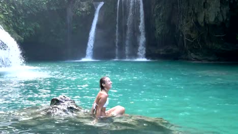 Mujer-joven-contemplando-una-hermosa-cascada-en-la-isla-de-Cebú-en-Filipinas.-Gente-de-viaje-naturaleza-concepto-de-amar.-Una-persona-sólo-disfrutando-al-aire-libre-y-la-tranquilidad-en-un-ambiente-tranquilo