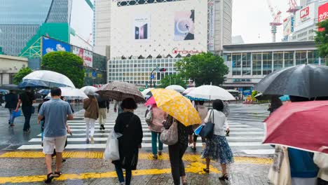 Shibuya-district-at-rainy-night-with-crowd-passing-crosswalk.-Tokyo,-Japan.-4K-Timelapse.