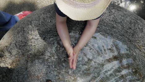 Child-Washing-Hands-in-Stone-Fountain-Basin