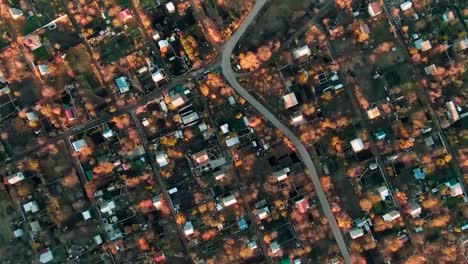 Vista-aérea-de-rotación-de-la-cámara-sobre-una-gran-ciudad-con-casas-y-un-día-caro-en-un-día-soleado-de-otoño