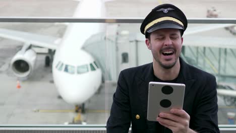 Young-Caucasian-pilot-checking-data-on-tablet-before-takeoff