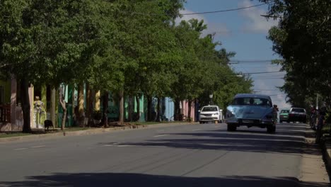 Kubanische-klassische-50er-Jahre-amerikanische-Oldtimer-fahren-auf-der-Straße-der-ländlichen-Kleinstadt-Vinales-Tal,-Kuba